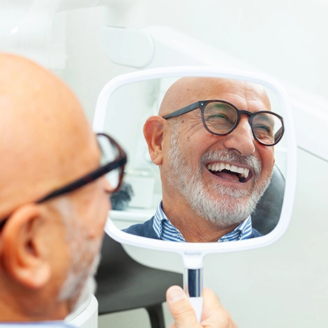 Middle-aged man smiling after discussing the cost of dental implants in Greenwood Village