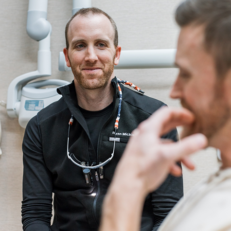 Dr. Mickle looking at patient in foreground