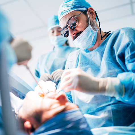 Dentist with mask and glasses treating a patient