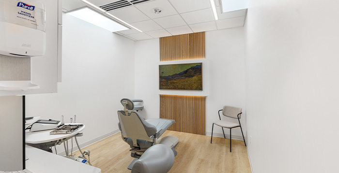 Dentist sitting and showing patient model of teeth
