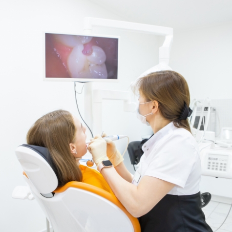 Dentist examining patient's mouth with intraoral camera