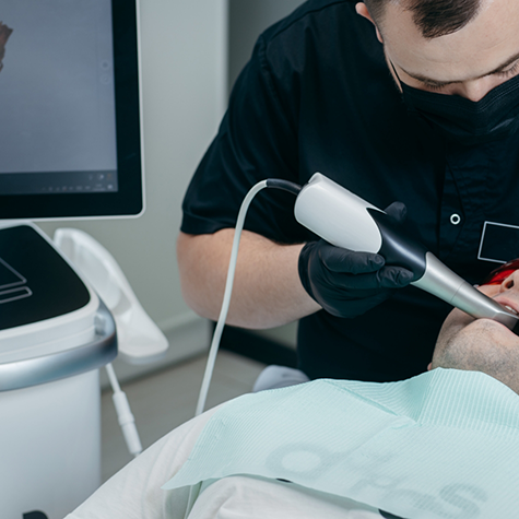 Dentist examining patient's mouth with intraoral camera