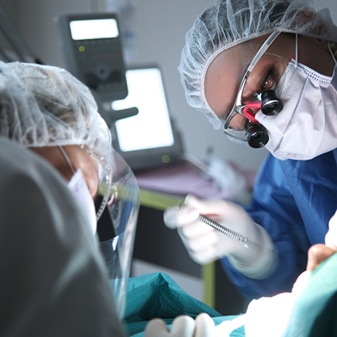 Dentists with masks performing gum disease treatment in Greenwood Village