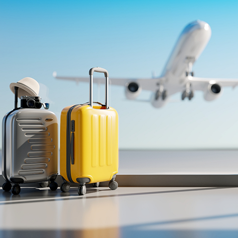 Suitcases in an airport with plane landing outside