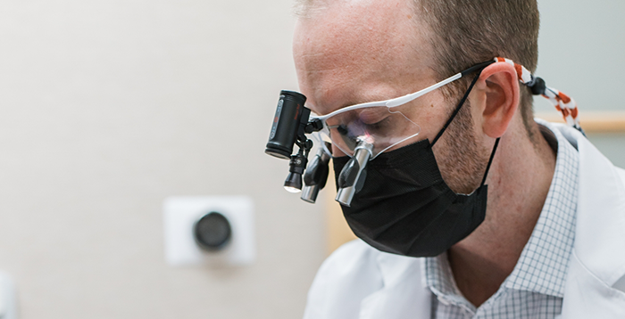 Dr. Ryan Mickle wearing magnifying glasses