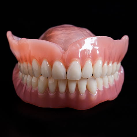 Close-up of two full dentures on black background