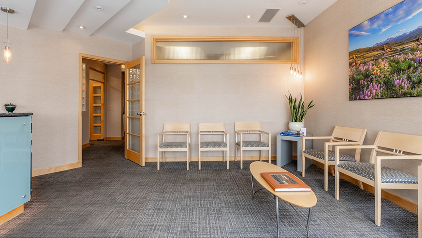 Waiting room with chairs, table, and open door