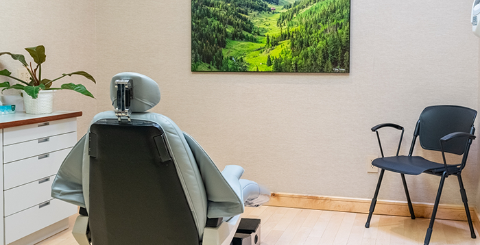 Dental chair in treatment room facing a painting