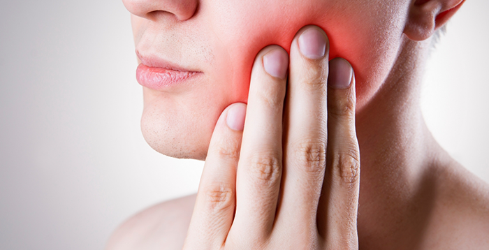 Close-up of woman with toothache rubbing jaw