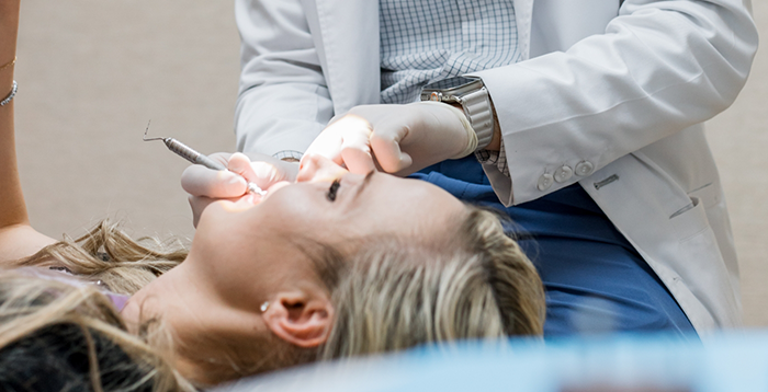 Woman leaning back in dental chair receiving treatment