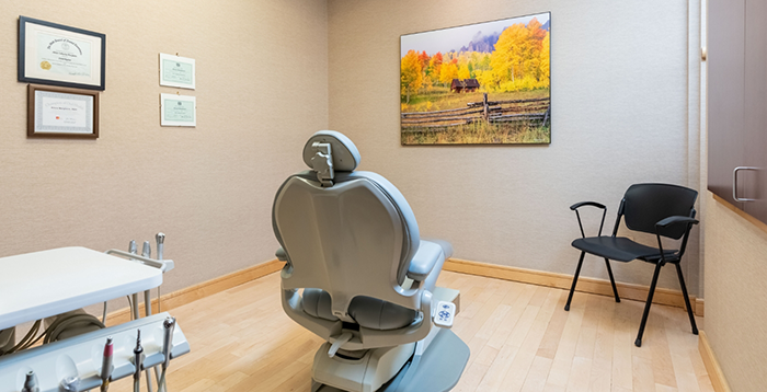 Dental chair in treatment area with painting on wall